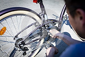 Bike repair. The man tightens the screw at the brakes with the key