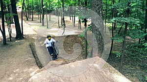 Bike rider is doing dirt jumping in the forest