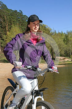 Bike riding - woman on bike in forest near lake