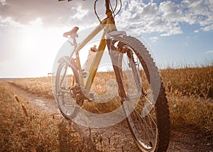 Bike silhouette at the sunset dirt road in the countryside