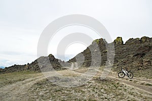 Bike standing on a road among cliff