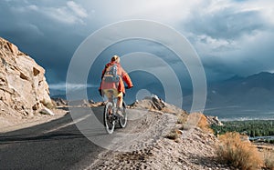 Bike tourist rides on Himalaya mountain road on way to buddist m