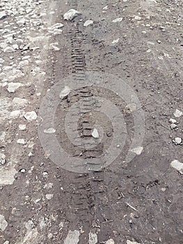 Bike, tractor, excavator, car, automotive tire tracks on muddy trail. Mud and wheel trace on road after rain.