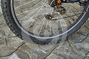 Bike wheel with pronounced tire tread and slightly rusty spokes