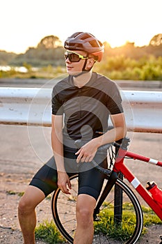 Biker athlete resting during riding the bike in nature countryside. Man in cycling gear