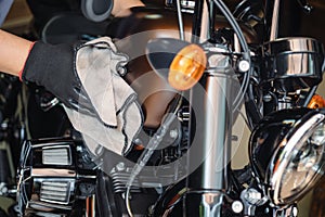 Biker clean a motorcycle , Polished and coating wax on fuel tank at garage. repair and maintenance motorcycle concept