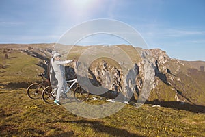 Biker couple with mountain bike pointing in distance at countryside