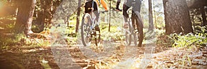 Biker couple riding mountain bike in the forest