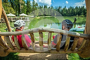 Biker couple on a tour at Lake Bloke resting on a wooden swing