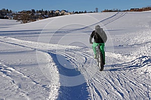 A biker is driving with a Fatbike through the snow photo