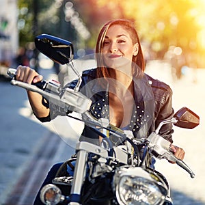 Biker girl in a leather jacket on a motorcycle