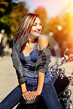 Biker girl in a leather jacket on a motorcycle