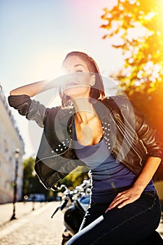 Biker girl in a leather jacket on a motorcycle