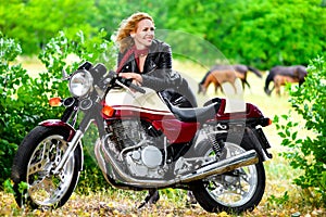 Biker girl in leather jacket on a motorcycle