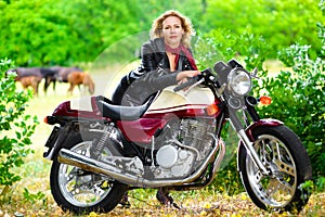 Biker girl in leather jacket on a motorcycle