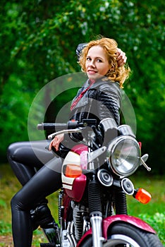 Biker girl in leather jacket on a motorcycle