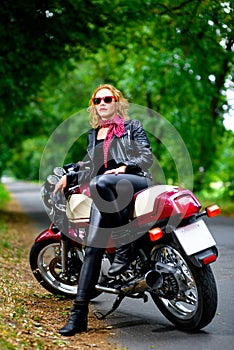 Biker girl in leather jacket on a motorcycle