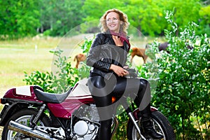 Biker girl in leather jacket on a motorcycle