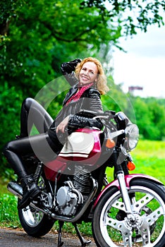 Biker girl in leather jacket on a motorcycle