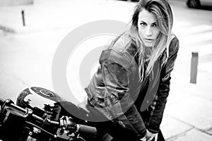 Biker girl in a leather jacket on a motorcycle