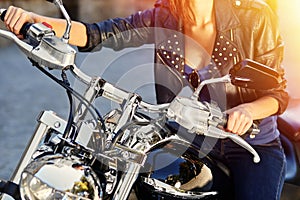 Biker girl in a leather jacket on a motorcycle