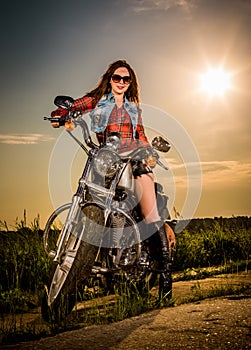 Biker girl sitting on motorcycle