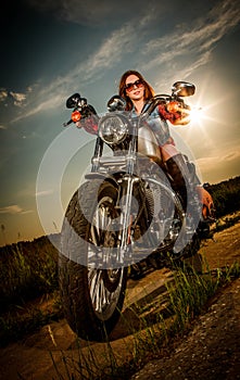 Biker girl sitting on motorcycle