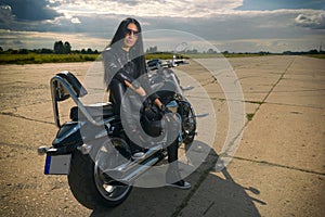 Biker girl sitting on a motorcycle.