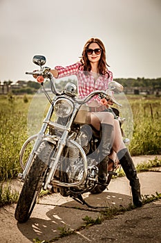 Biker girl sitting on motorcycle