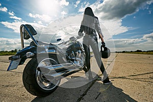 Biker girl standing by a motorcycle