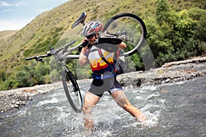 Biker goes over mountain river