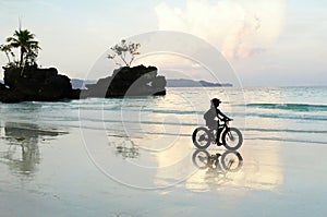 Biker and her reflection in Boracay Beach