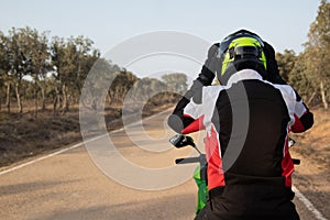 Biker with his equipment, putting on the safety helmet on his motorcycle before traveling.