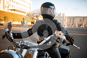 Biker in leather jacket and helmet with visor