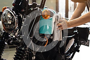 Biker man cleaning motorcycle , Polished and coating wax on fuel tank at garage. repair and maintenance motorcycle concept
