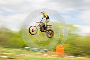 Biker on motocross jump in motion