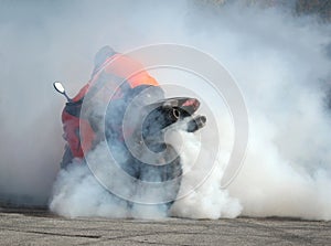 Biker on a motorcycle drifts in clouds of smoke