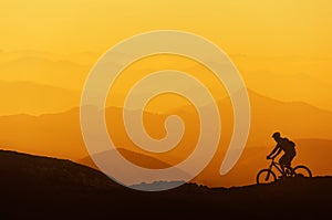 Biker riding on mountain silhouettes background