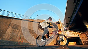 Biker spins handlebars while jumping, slow motion.