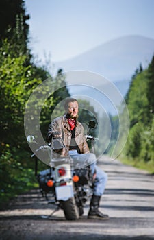 Biker standing by his custom made cruiser motorcycle