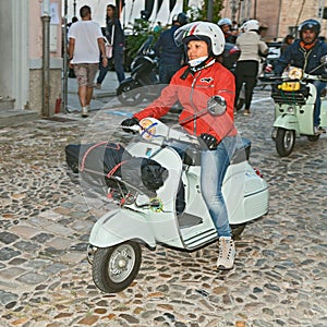 Biker woman riding a vintage italian scooter Vespa