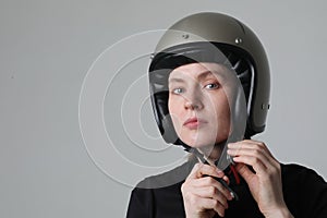 Biker young woman putting her helmet posing over white background. Mock-up.