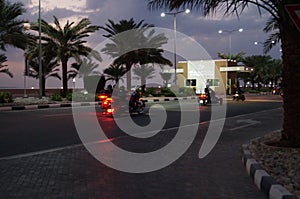 Bikers ride at night on the highway on Al-Marjan Island. United Arab Emirates