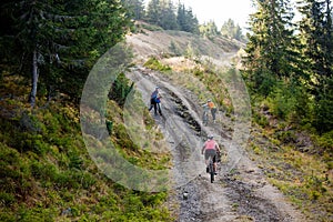 Bikers travel in difficult conditions in autumn forest