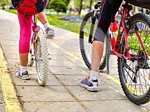 Bikes bicyclist girl. Children feet and bicycle wheel. Low section.