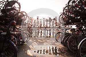 Bike parking in amsterdam during blue hour shot against the sun with a water poddle in front photo