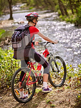 Bikes cycling girl with big rucksack cycling fording throught water .