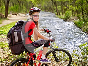 Bikes cycling girl with big rucksack cycling fording throught water into park.