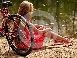 Bikes cycling girl sits on bicycle shore into park .