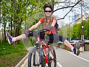 Bikes cycling girl wearing helmet with legs apart.
